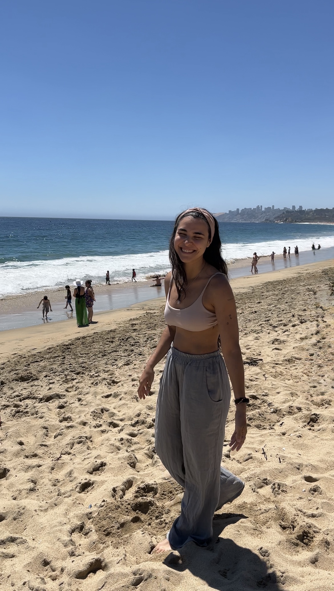 Agus sonriendo en la playa, con el mar de fondo